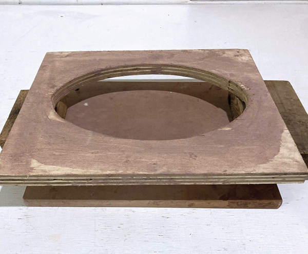 1 After creating a slump mold with plywood and a jigsaw, raise the mold above a board using wooden blocks or bricks.
