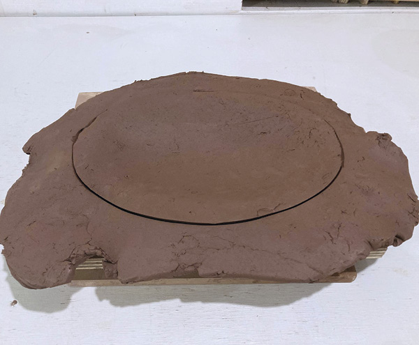 2 Drape a slab loosely over mold, tapping gently to achieve desired slump. Remove the excess, leaving a slight edge.