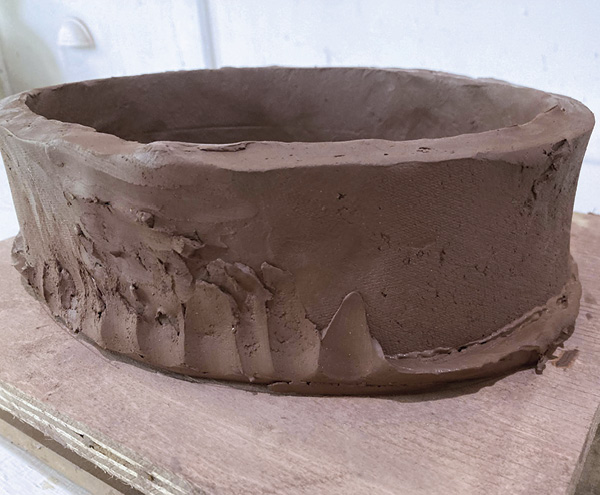 3 Score and slip the joins, add tall walls to the floor, then wrap the beveled edge of the slab up over the walls.
