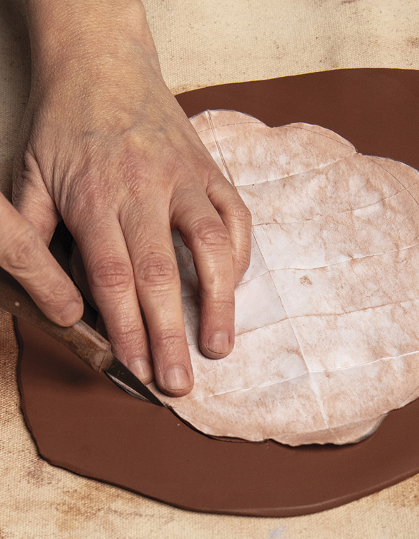 1 Following the outline of the paper stencil, use a knife to cut the slab.