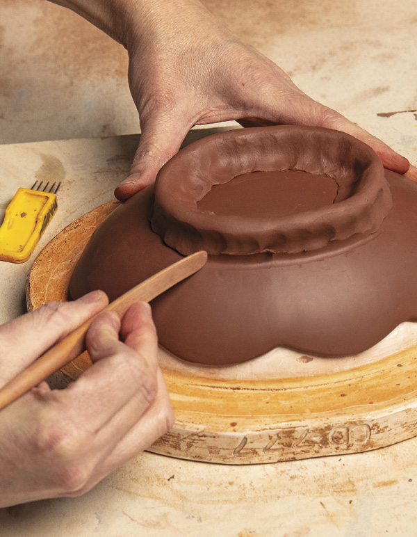 2 Use a wood tool to adhere the coil foot to the slab base.