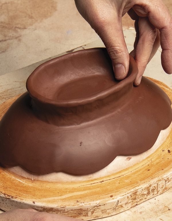 3 Using your index finger and thumb, pinch the coil up to make a tall foot.