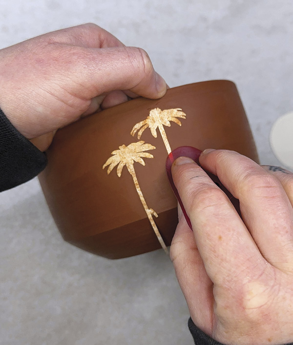 2 Place Tyvek stencils on clay and use a soft silicone rib to stick them down.