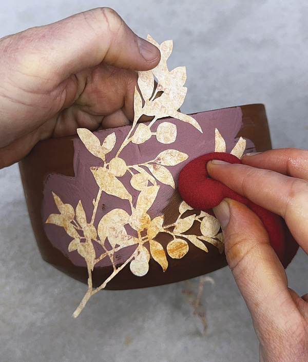 5 Apply two coats of colored slip, place stencils on top, and adhere.