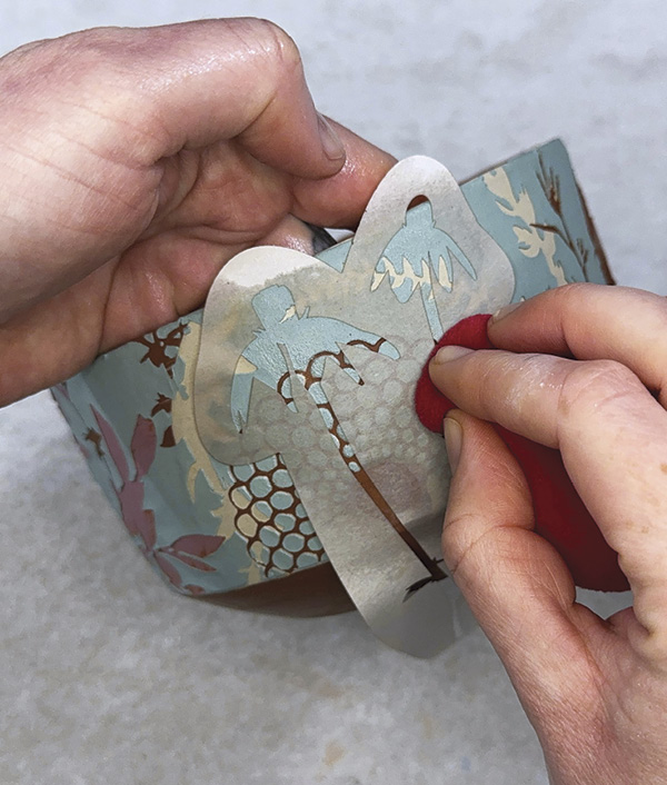 13 Place negative-space stencils, spritz with water, and adhere with a sponge.