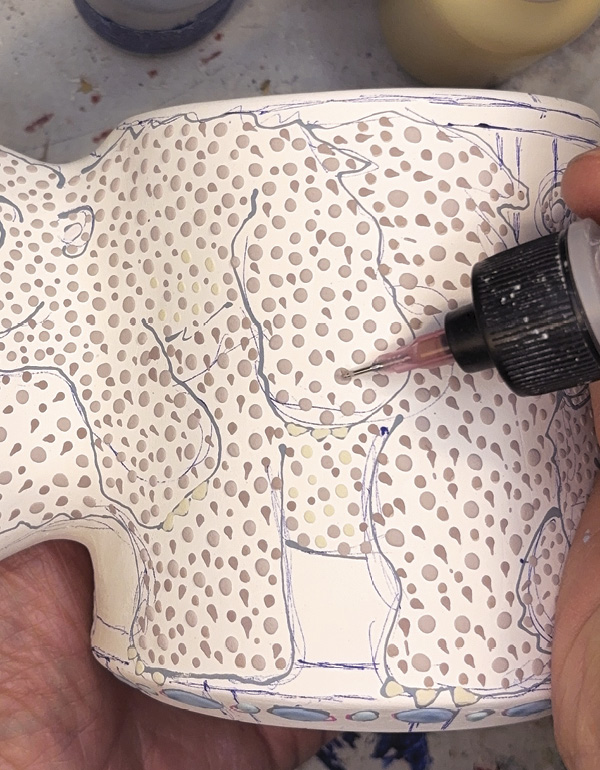 4 Add colorful designs, bisque fire again, apply a liner glaze before a final firing.