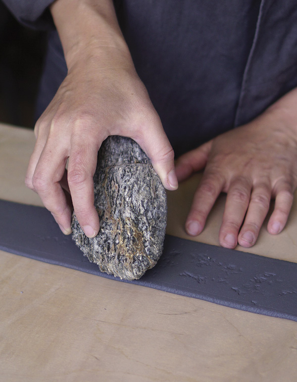 1 Using a rough rock, apply light pressure to the slab, controlling the depth.
