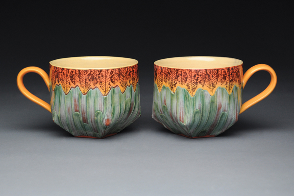 2 Cups from Cultivating Community through Shared Experiences, 5½ in. (14 cm) in width, slip transferred, hand built, earthenware, slip, underglaze, mason stain wash fired to cone 02 in an electric kiln, 2014.