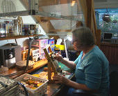 Johanna DeMaine with a pot on her easel, working in her well-vented studio.
