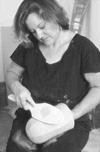 The wall thickness is evened (bottom to rim) by rhythmical paddling while slowly rotating the form with the inside hand.