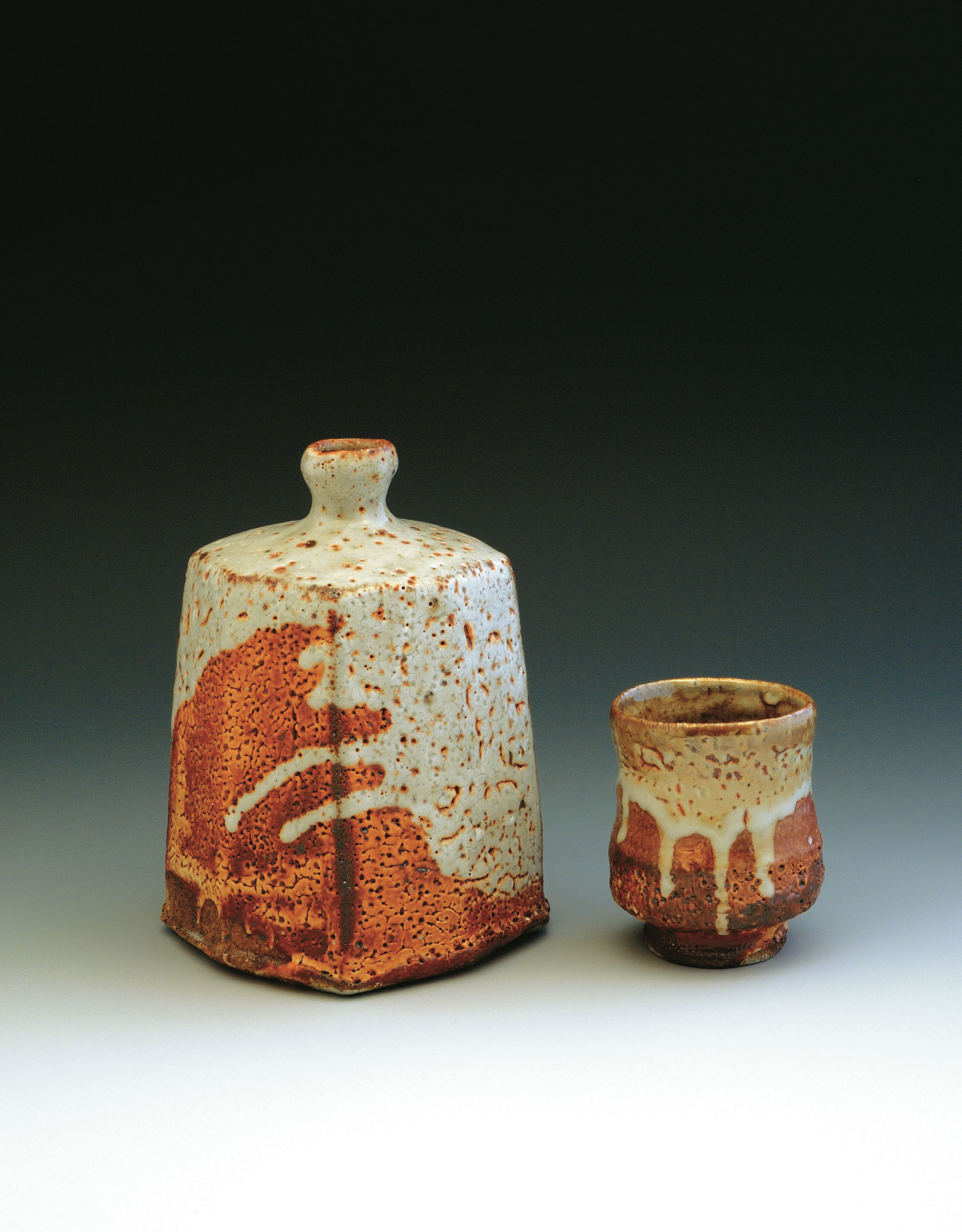 Squared and faceted bottle and yunomi, to 8 in. (20 cm) in height, thrown stoneware with red Shino glaze, soda fired to Cone 12.