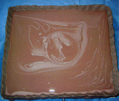 4. A clay wall surrounds the block, and casting slip is flooded into the area. 