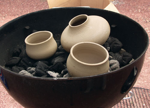 Fig.1 Lift out the cooking grid, spread out the coals and put the preheated pots on the coals.