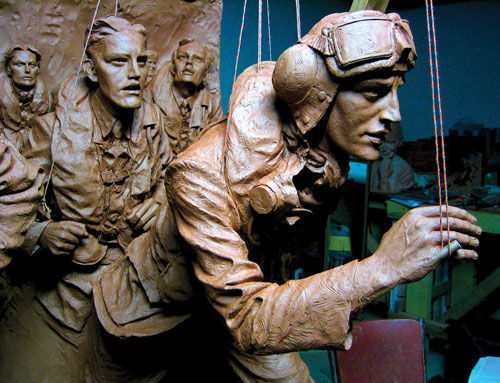 The Battle of Britain London Monument in progress, with a suspended wooden armature that was built as the figures were constructed.