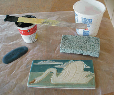 2. Necessary tools: plastic drop cloth, gloves, containers, water, sponge, stir stick, grout, and squeegee.
