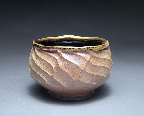 Finished faceted bowl with trimmed foot, wood fired.