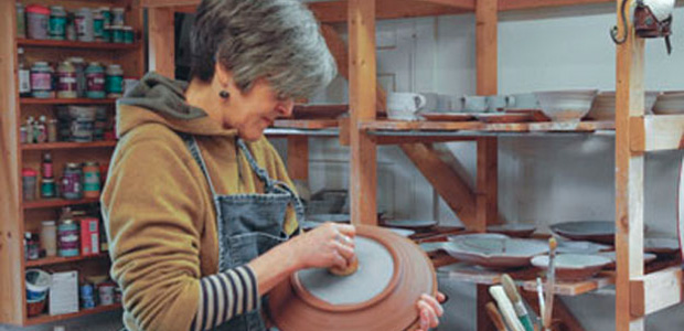 Photo of Victoria Christen hard at work in her pottery studio.