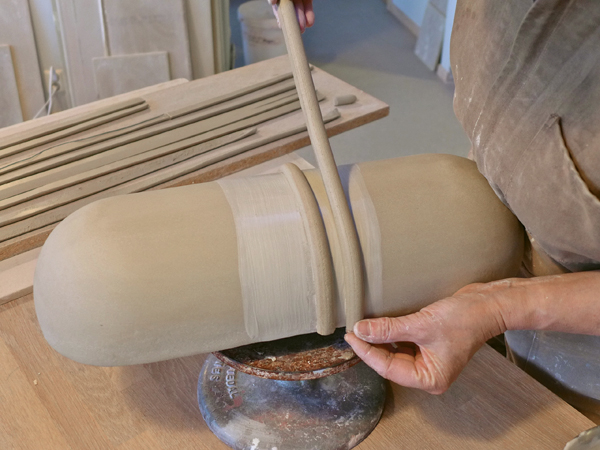 8. Brush thick slip onto the form in sections and press the coils onto the bowl.