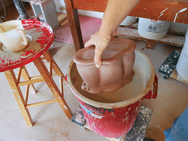 12 Apply terra sigillata to areas remaining bare then cover those areas with wax. Dip the dry pot and lid into a thin, white slip.