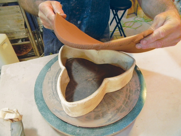 5. Roll out and drape a slab of clay over the bisqued mold.