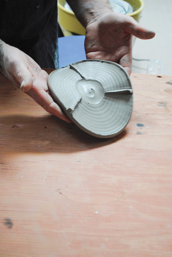 1 Start the spout with a thrown clay disk with a recessed center, then make shallow cuts into the outer area of the disk to create textures and raised lines that divide the circle into three sections.