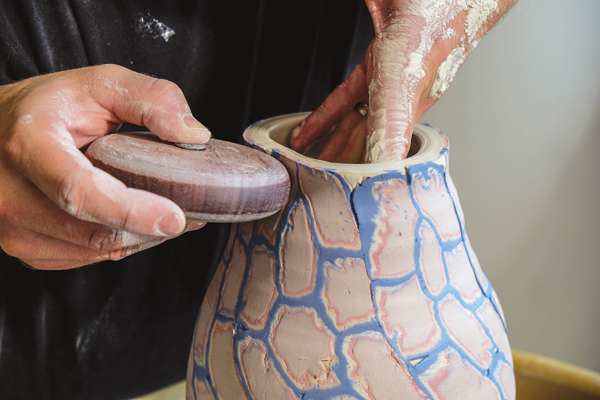 5 Forming the vessel using pressure from one hand inside the piece and pressing against it with wooden roller on the outside.