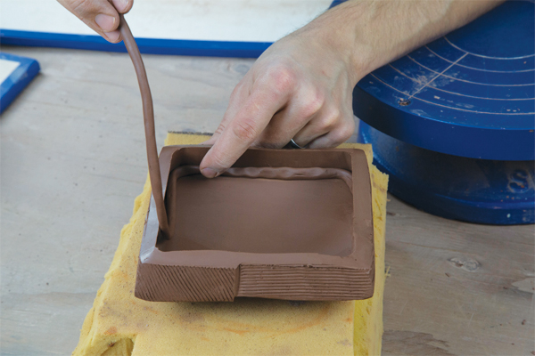 19 Take the newly separated lid off of the box and add a coil to the joint inside the lid.
