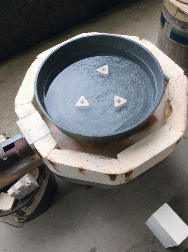 1 Fill a metal automobile oil drip pan with water and use a raku burner to bring it to a boil. 