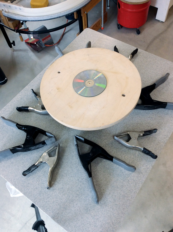 3 Prepare your working area with the a wooden bat, 2 CDs, and a number of clamps.