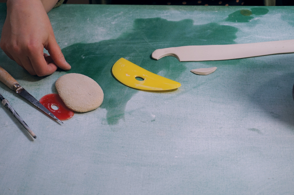 7 Roll out a tapered coil, then cut out each scallop by bending a yellow Mudtools rib and pressing through the clay.