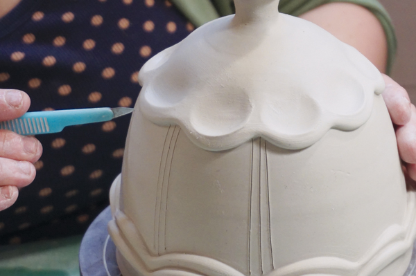 15 Using a scalpel, draw thin, vertical lines between the scallops for an extra decorative touch.