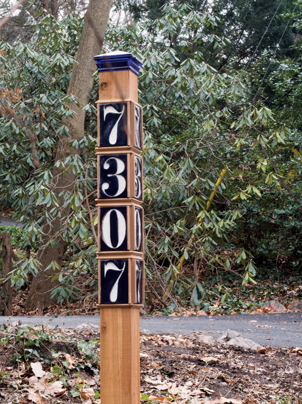 Tiles mounted on a post, shown in daylight and at night (top of post). The reflective paint provides a very visible, high-contrast sign.