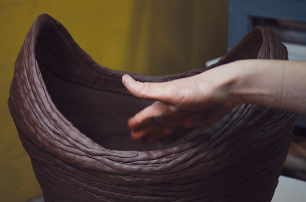 10 Paddle the rim of the piece with a flat palm to compress and shape the vessel, creating a piled look.