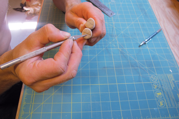 6 Carve a small groove into the end of the long dowels for the tensioned guitar string to rest in using an X-Acto knife.
