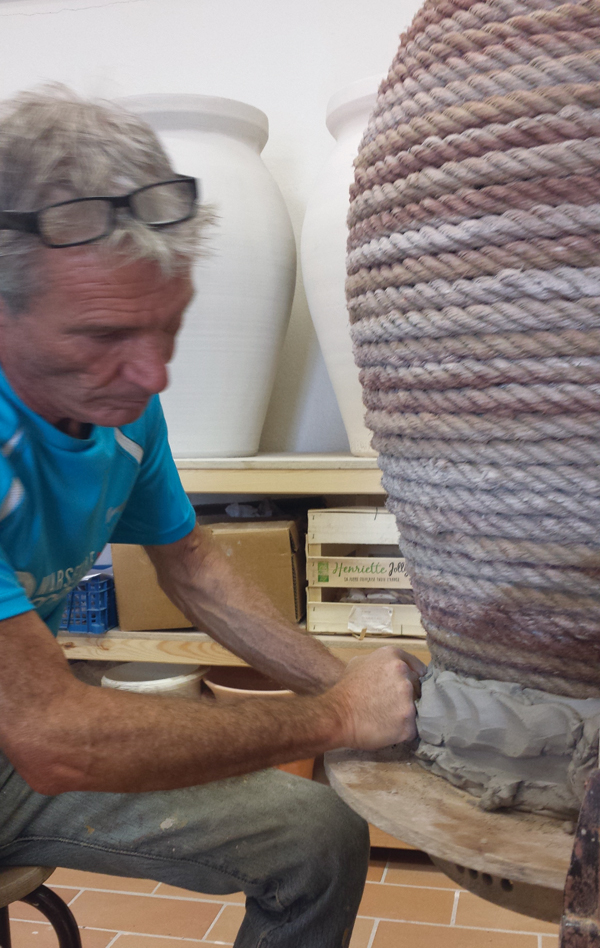 7 Attaching the first coils of clay to the armature and slab base of the jar, smoothing and compressing by hand.