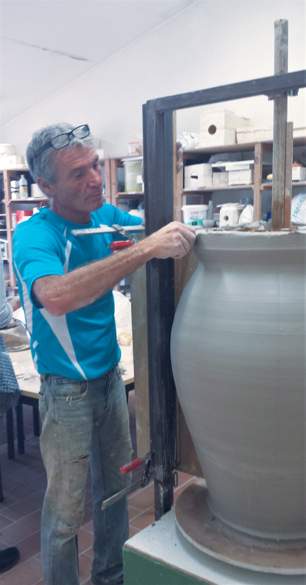 12 Cutting excess clay from the jar’s rim using a fettling knife.