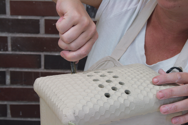 18 Use a round hole punch to cut holes in the lid following the bubble-wrap pattern.