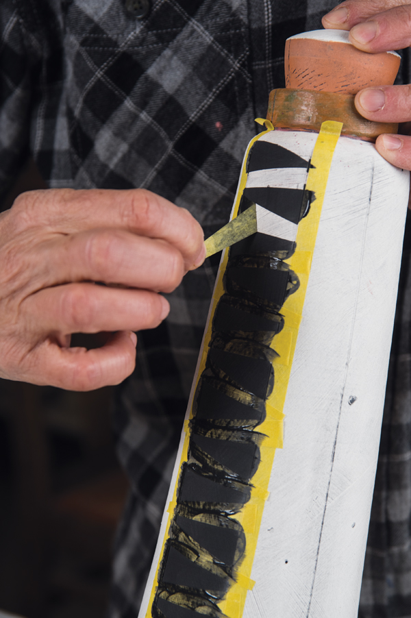 19 Paint underglaze over the masking tape stencil, allow it to dry, then remove the tape.