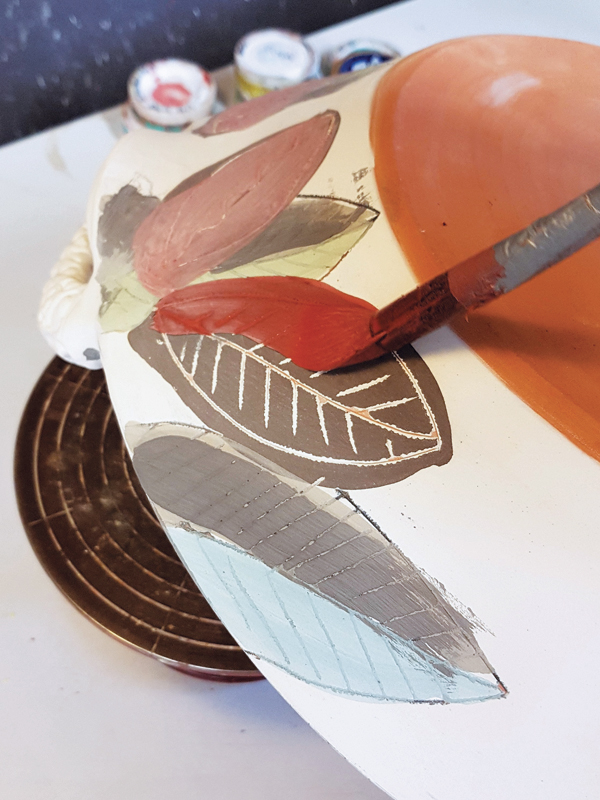 6 Brush over the black slipped parts with a copper glaze so they bleed green. The glaze is made from a transparent glaze.