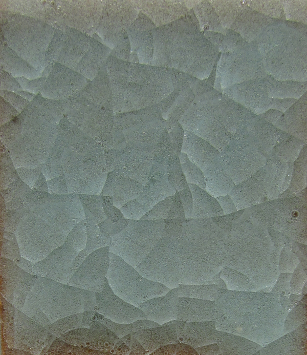 Test tile of Snowflake Crackle #4 with 0.2% copper carbonate on Brownstone clay, fired to cone 6 in an electric kiln.