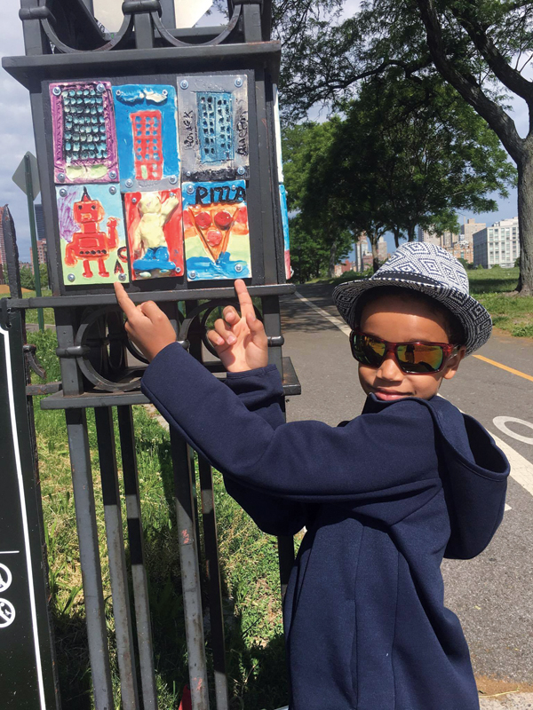 9 Alex Coln with his finished ceramic plaque installed at Rainey Park for Neighborhood Stories, 2017.