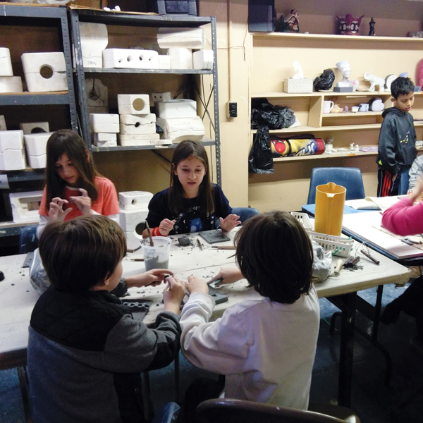 2 Children working on decorating their tiles for the Rainey Park installation project Neighborhood Stories, 2017.