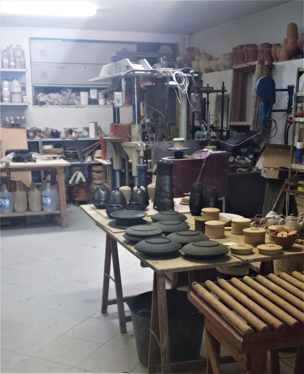 Campos’ studio with works in progress on the table in the foreground.