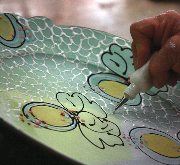 3 With an applicator bottle filled with a lighter underglaze color, apply additional details. This will melt down to give a visual texture.