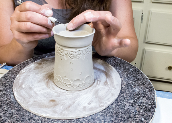 8 Use your finger on the inside of the raised foot to stretch and form a soft curve. Then cut a scalloped edge.