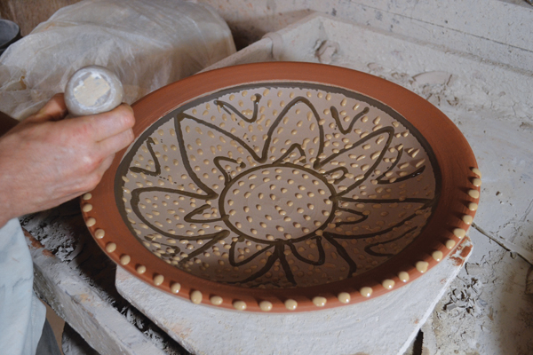 9 Decorate the rim and interior of the platter with multiple slips.