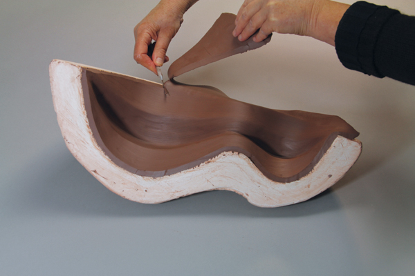 11 Cut the edges and leave the clay slab in the mold to stiffen up or flip out and prop to stiffen.