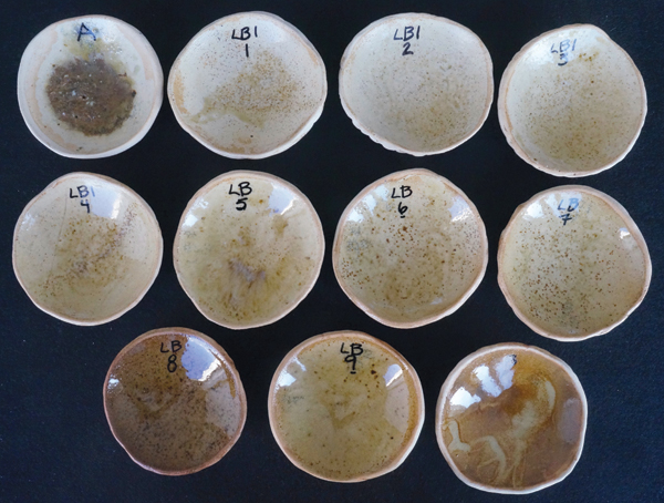 4 Fired results of the line blend. Top row far left is A, 100% wood ash. Bottom row far right is B 100%, a blend of equal parts nepheline syenite, red clay, and JM Frit 169.