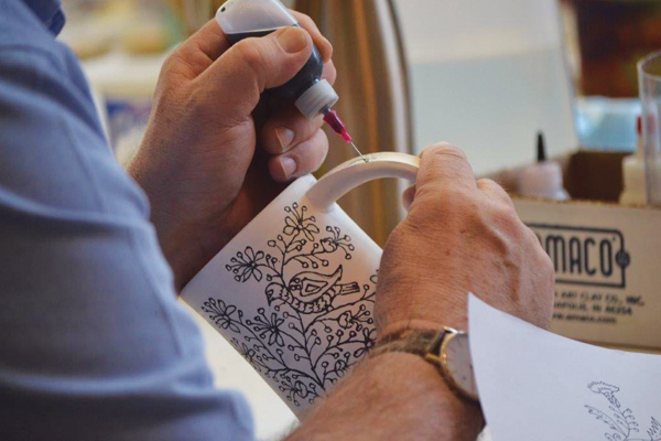 5 Arthur DeBow decorates a Phil Sellers mug.