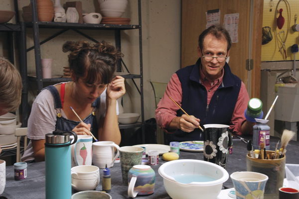 2 Painters Anna Moriarty-Lev and John MacDonald apply underglaze to their mugs. Photo: Jack Criddle.